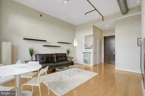 a living room with granite countertop couches a flat screen tv and kitchen view