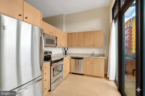 a kitchen with granite countertop a refrigerator and a stove