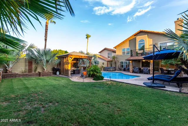 a view of an house with backyard and a patio