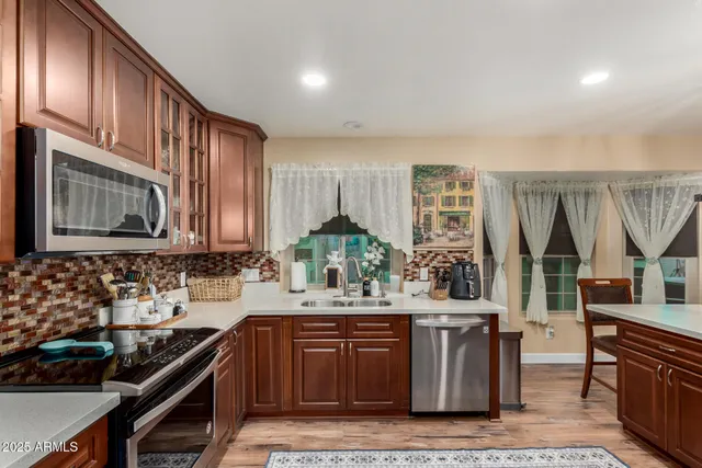 a kitchen with granite countertop a center island a refrigerator and wooden cabinets