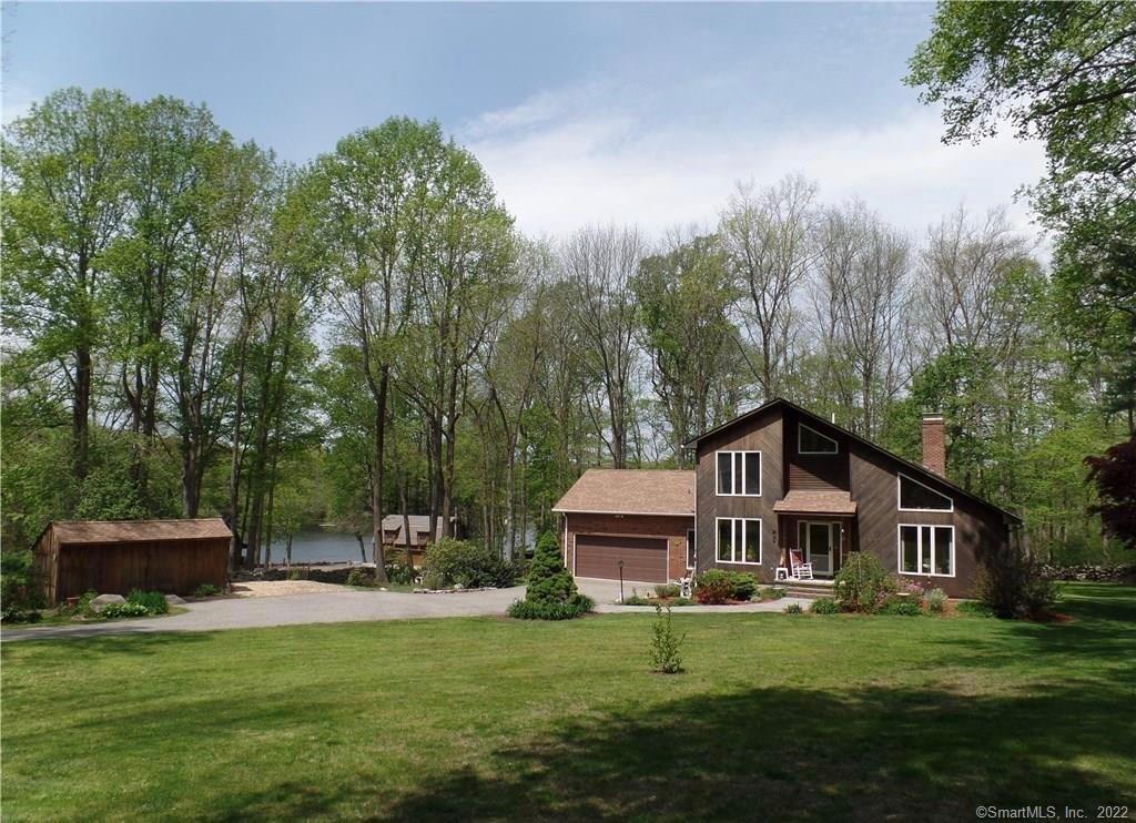 a front view of a house with a garden and trees