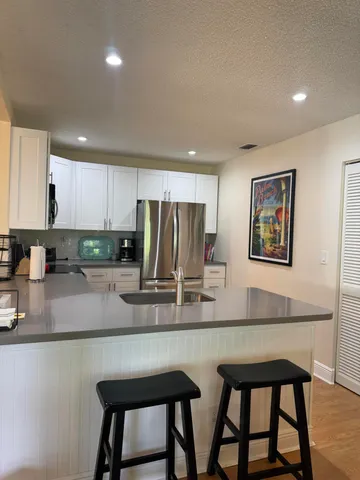 a kitchen with stainless steel appliances granite countertop a stove a sink a microwave a dining table and chairs