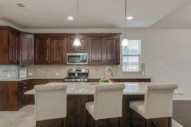 a kitchen with a table chairs sink and cabinets