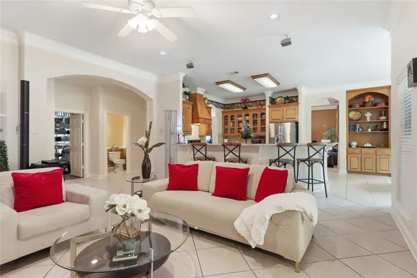 a living room with furniture kitchen view and a chandelier