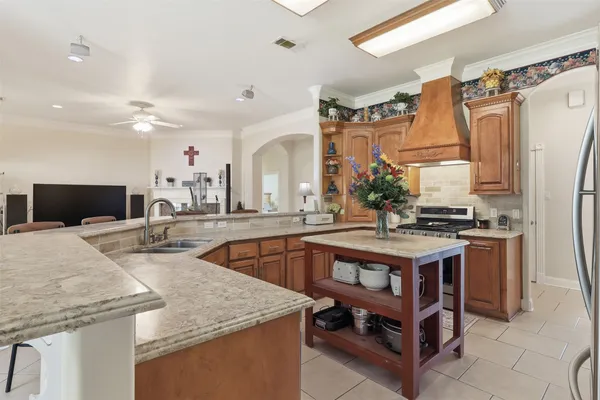 a kitchen with stainless steel appliances granite countertop a sink and a refrigerator