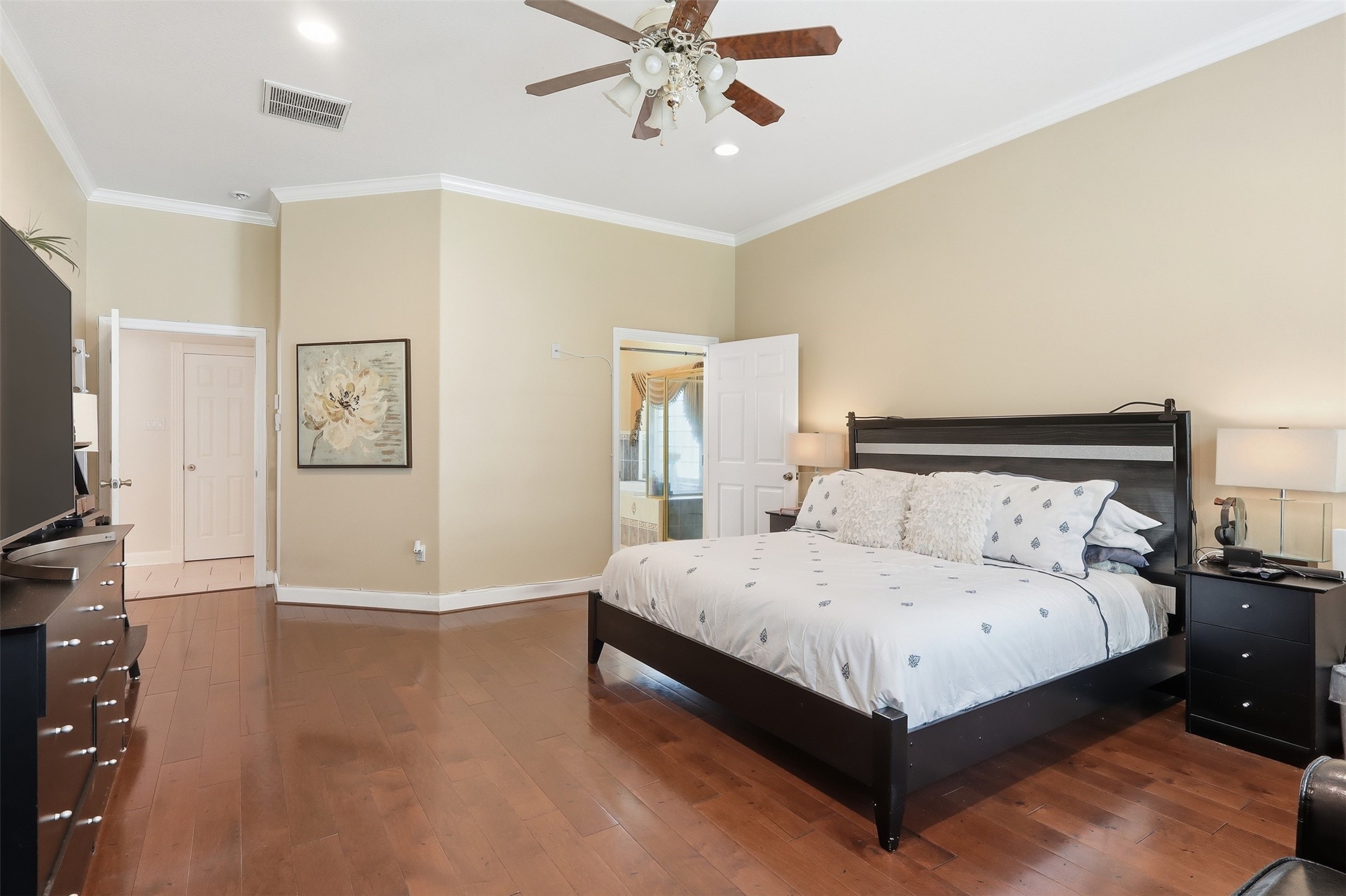 21411 Stargrass Drive Spring, TX 77388 - Photo 14 of 24 Massive primary suite with beautiful wood flooring, recessed lighting, and direct access to the luxurious ensuite bath.