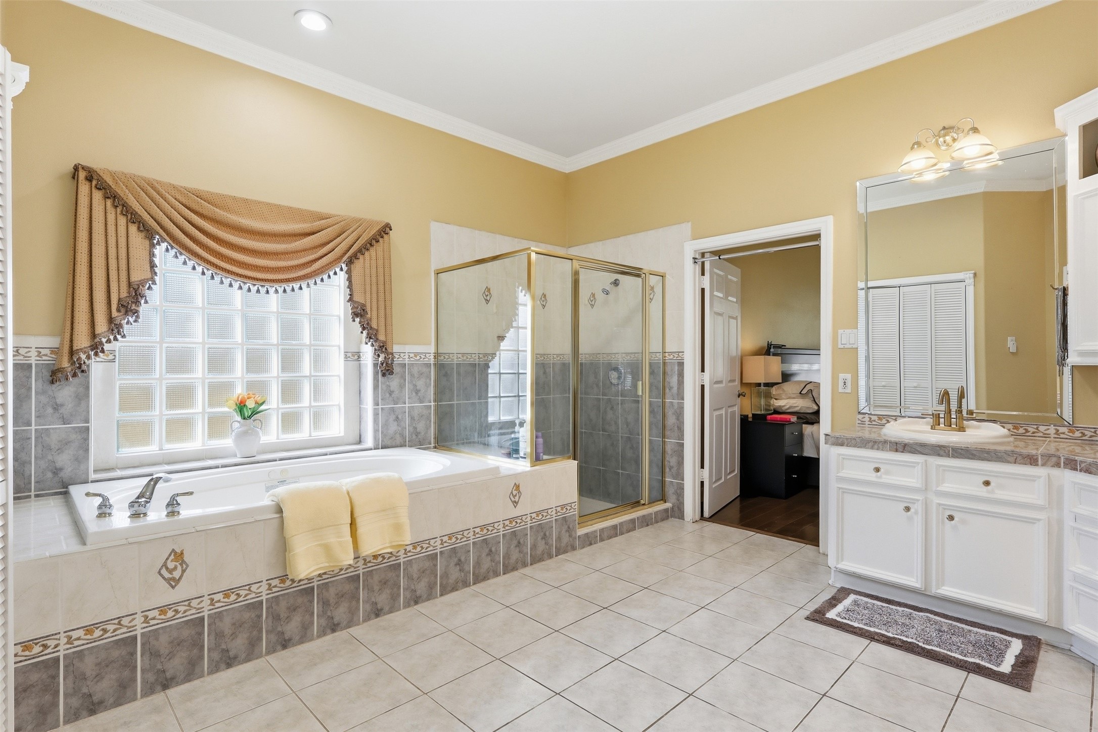 21411 Stargrass Drive Spring, TX 77388 - Photo 15 of 24 Bright and airy primary bath with a large soaking tub, walk-in shower, and expansive vanity space—everything you need for a private home spa.