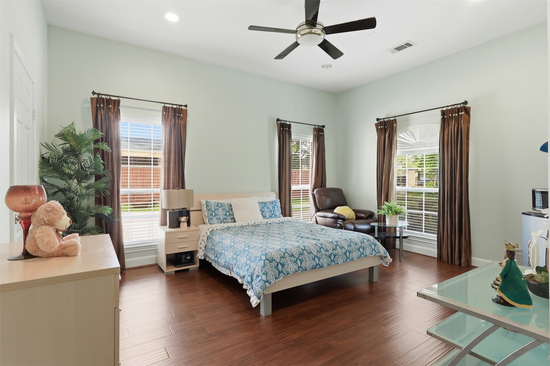 21411 Stargrass Drive Spring, TX 77388 - Photo 16 of 24 Perfect for multi-generational living! This expansive bedroom is large enough to serve as a second primary suite, complete with rich wood-look flooring, multiple windows, and a generous layout.