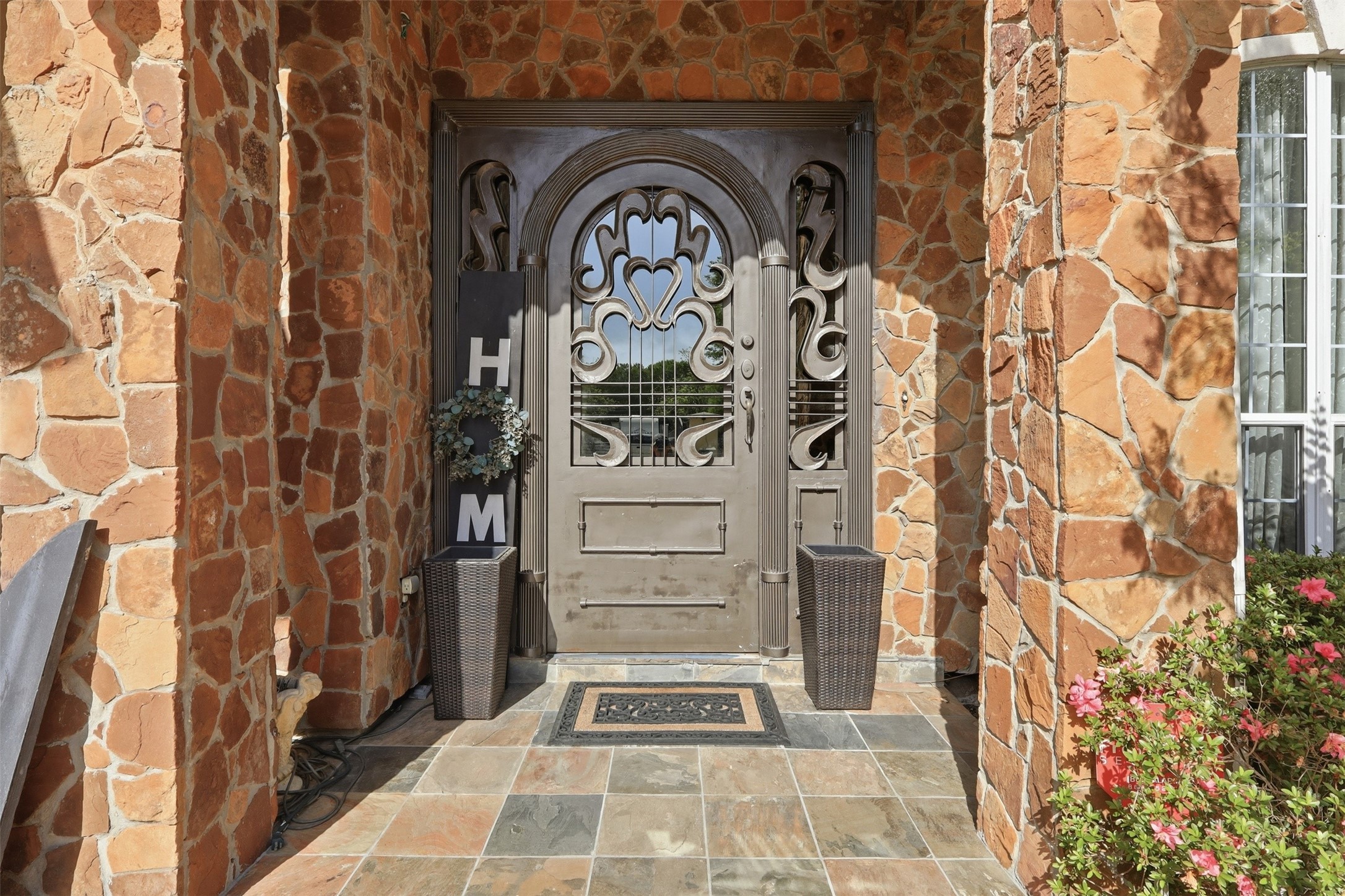 21411 Stargrass Drive Spring, TX 77388 - Photo 7 of 24 A grand first impression! Custom wrought-iron scrolled door set against a rustic stone entryway with slate tile flooring.