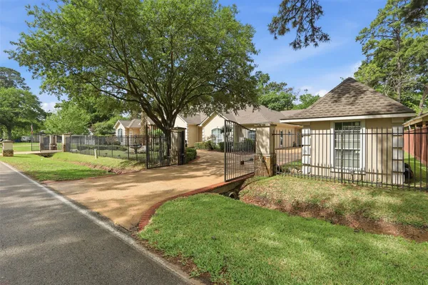 a view of a house with a big yard and large tree