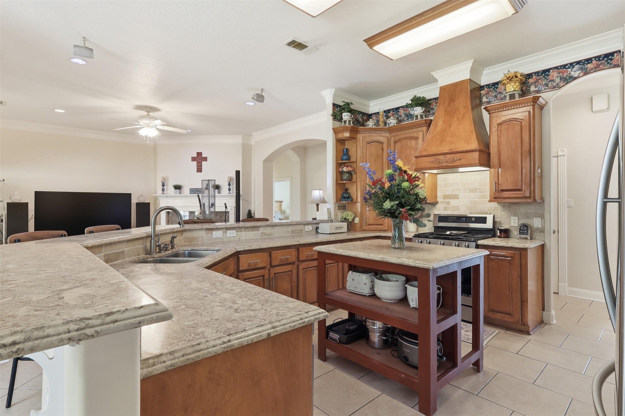 21411 Stargrass Drive Spring, TX 77388 - Photo 9 of 24 Designer kitchen with premium granite countertops, a built-in gas range, and ample prep space. The breakfast bar overlooks the family room, creating a bright and airy atmosphere.