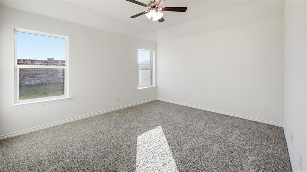 419 Epiphany Lane Lavon, TX 75166 - Photo 18 of 31 Spacious room featuring neutral carpet flooring, white walls, two windows, and a ceiling fan with integrated lighting