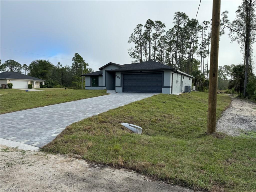 2530 Catron Circle Lehigh Acres, FL 33971 - Photo 1 of 27 a view of a yard in front of a house with a large tree