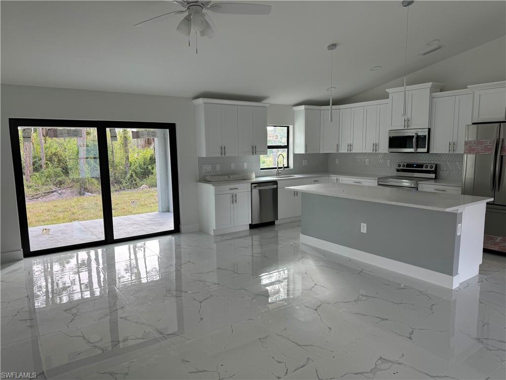 2530 Catron Circle Lehigh Acres, FL 33971 - Photo 11 of 27 a kitchen with stainless steel appliances granite countertop a stove top oven a sink a counter top space cabinets and a window