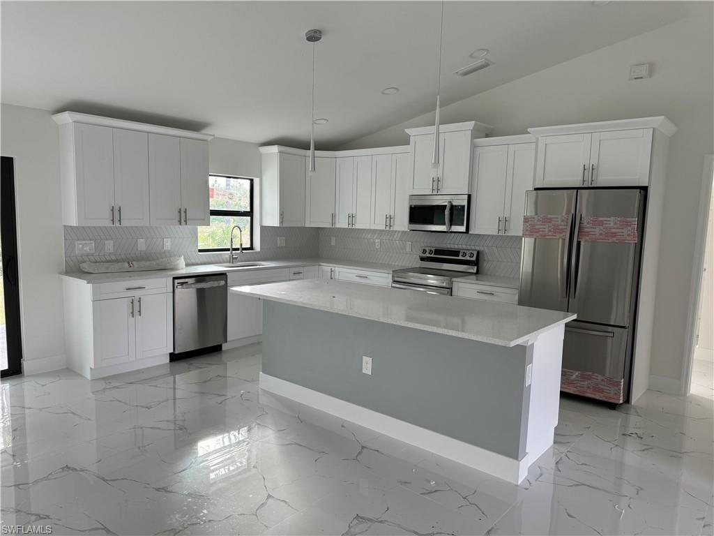 2530 Catron Circle Lehigh Acres, FL 33971 - Photo 12 of 27 a kitchen with stainless steel appliances a refrigerator sink stove microwave and cabinets