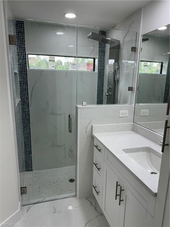 2530 Catron Circle Lehigh Acres, FL 33971 - Photo 13 of 27 a bathroom with a shower sink and mirror