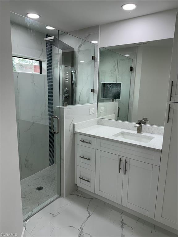 2530 Catron Circle Lehigh Acres, FL 33971 - Photo 16 of 27 a bathroom with a shower sink and mirror