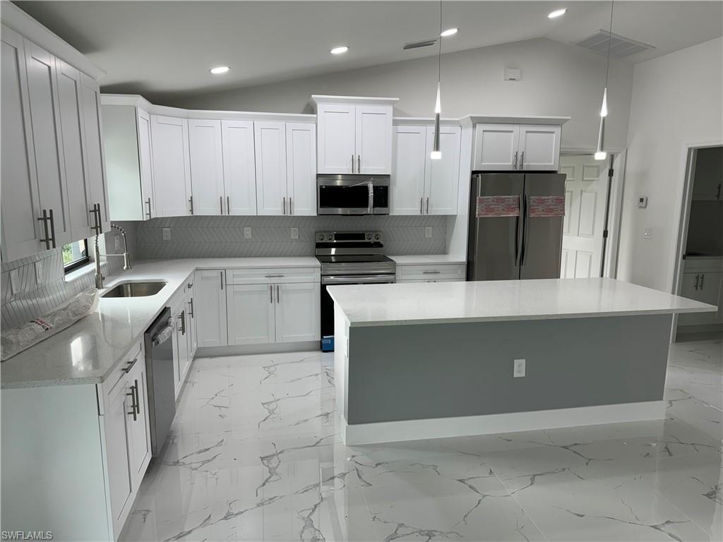 2530 Catron Circle Lehigh Acres, FL 33971 - Photo 6 of 27 a kitchen with a sink a stove and refrigerator