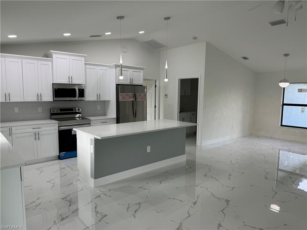 2530 Catron Circle Lehigh Acres, FL 33971 - Photo 7 of 27 a large kitchen with stainless steel appliances a stove a sink a microwave and a refrigerator