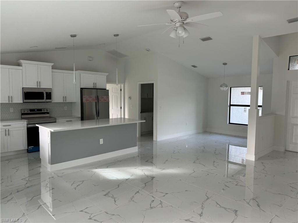 2530 Catron Circle Lehigh Acres, FL 33971 - Photo 10 of 27 a view of a kitchen with a sink and dishwasher a refrigerator with white cabinets