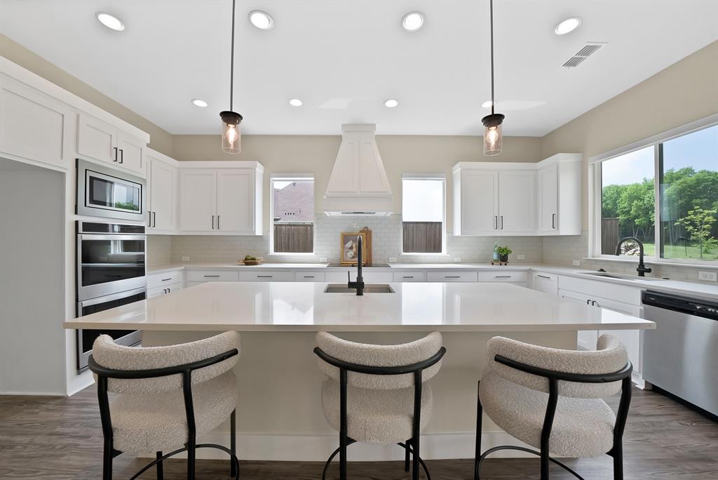 2223 Providence Way Nevada, TX 75173 - Photo 24 of 40 a kitchen with stainless steel appliances kitchen island a table and chairs