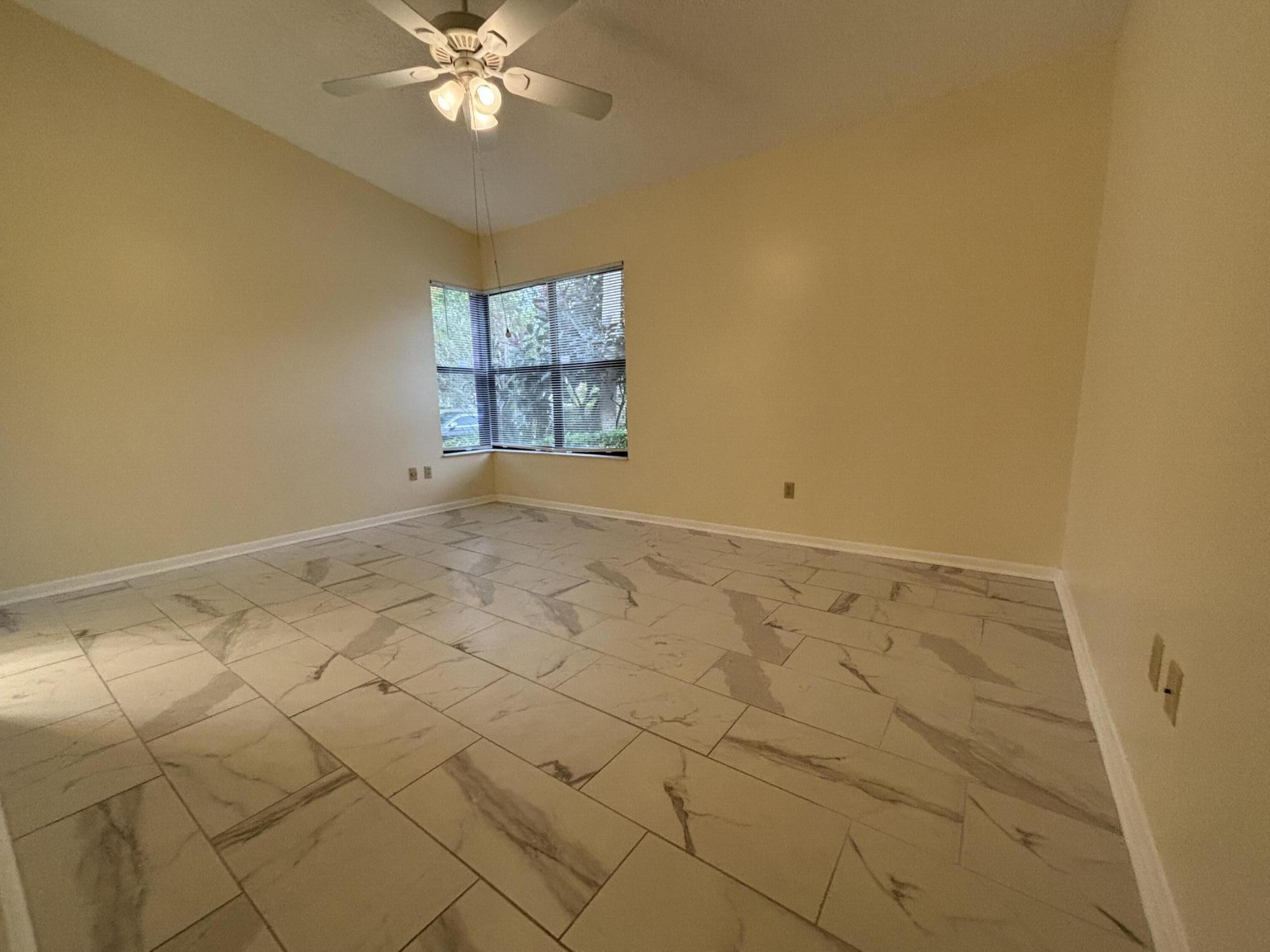3872 Vine Trail, Unit D Lake Worth, FL 33467 - Photo 11 of 18 an empty room with windows and ceiling fan