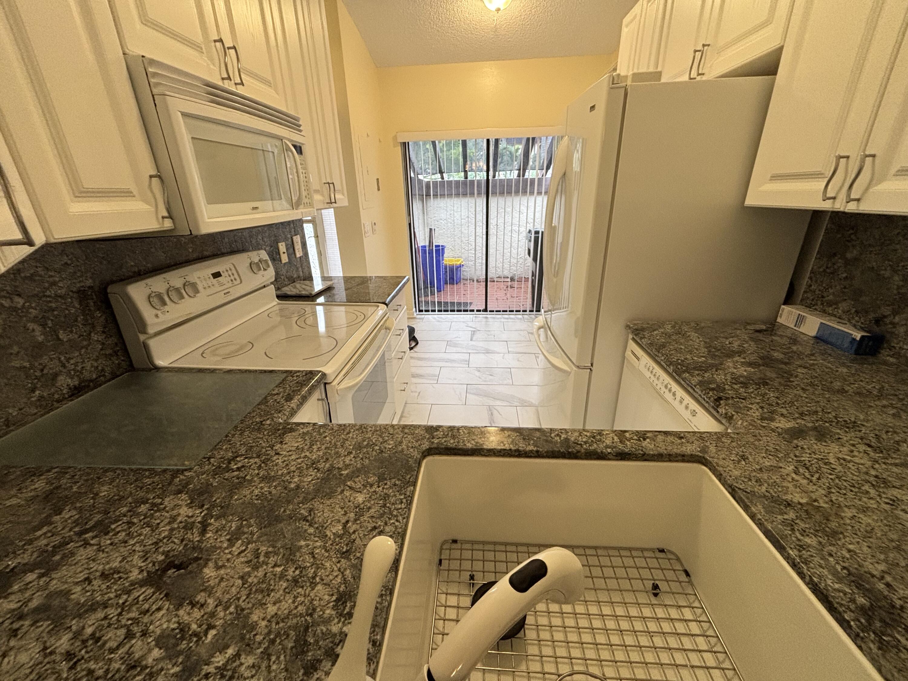 3872 Vine Trail, Unit D Lake Worth, FL 33467 - Photo 5 of 18 a bathroom with a granite countertop sink and a mirror