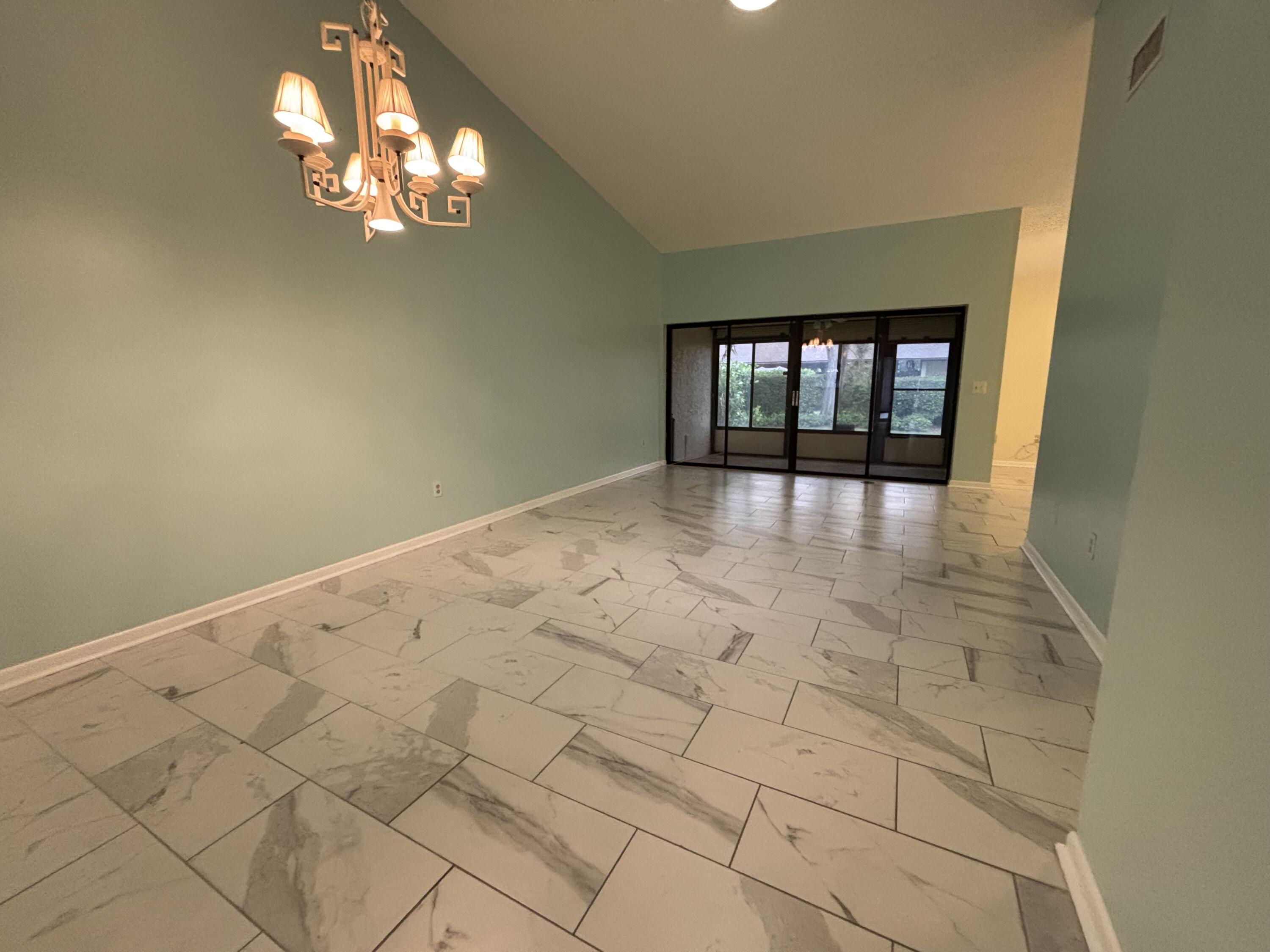 3872 Vine Trail, Unit D Lake Worth, FL 33467 - Photo 6 of 18 a view of an empty room with a chandelier