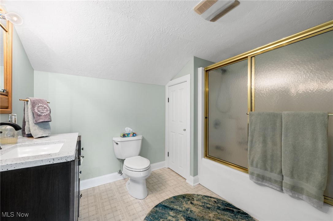 3945 Columbia Road Medina, OH 44256 - Photo 18 of 40 Bathroom featuring lofted ceiling, a textured ceiling, vanity, tile patterned floors, and enclosed tub / shower combo