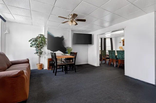 a living room with furniture a flat screen tv and a potted plant