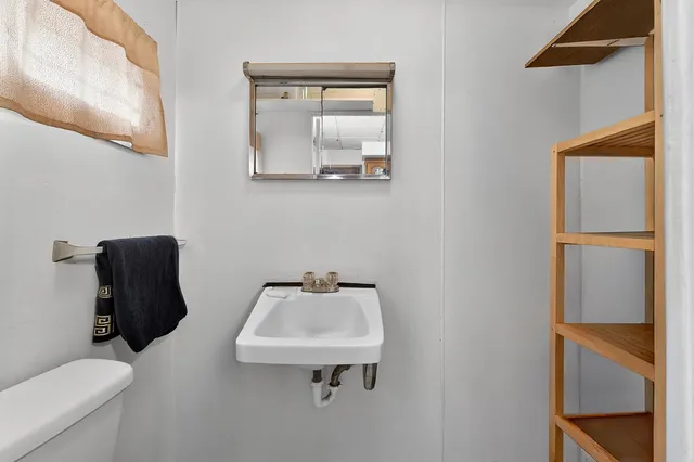 a bathroom with a sink mirror and toilet