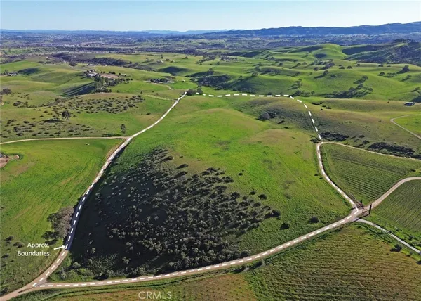an aerial view of a residential houses with outdoor space and trees