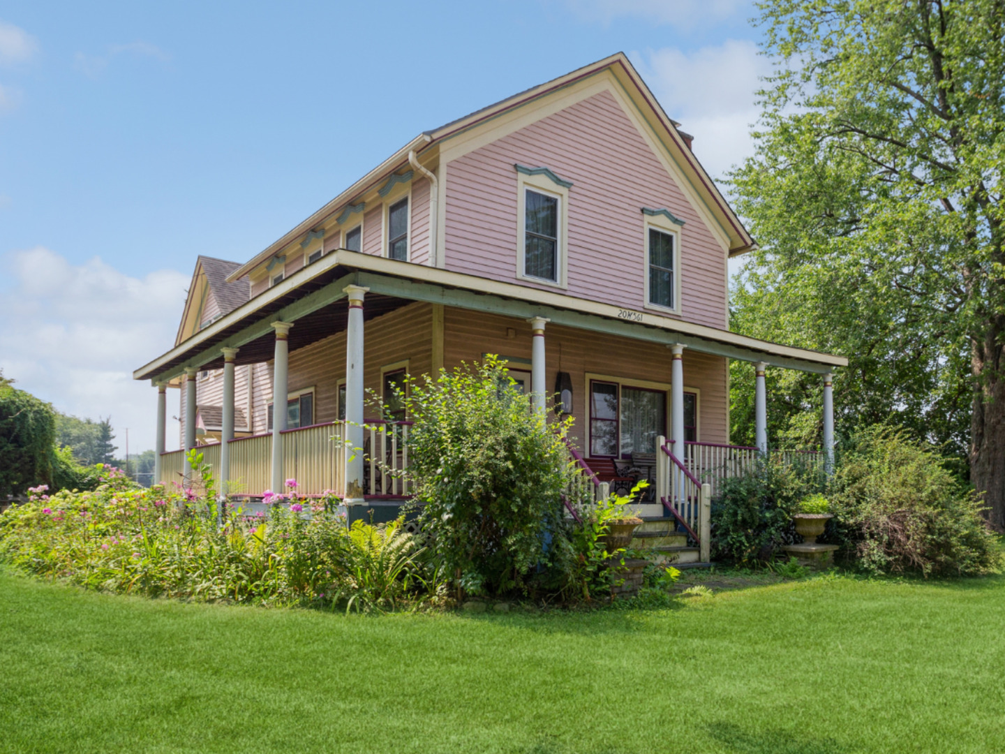 a front view of a house with a garden and plants