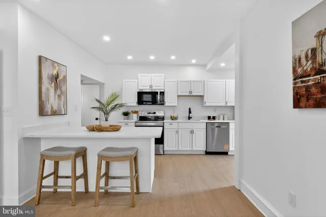 a kitchen with white cabinets and stainless steel appliances
