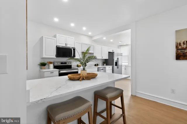 a kitchen with a sink a counter and chairs