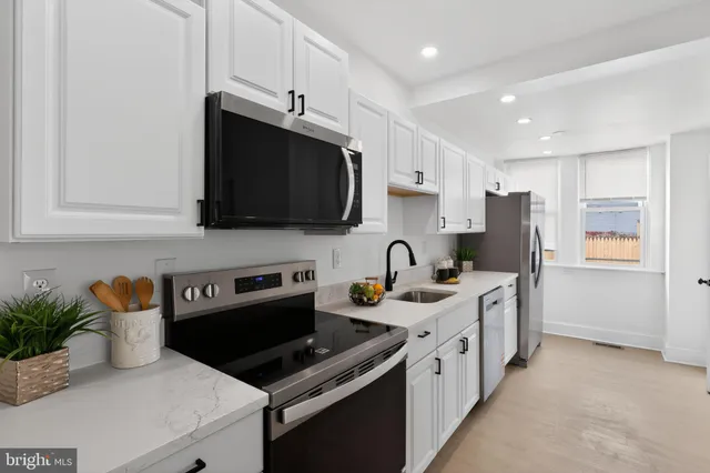 a kitchen with stainless steel appliances kitchen island granite countertop a sink a stove and a refrigerator
