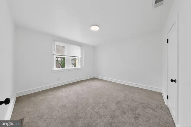 an empty room with windows and entrance to other room