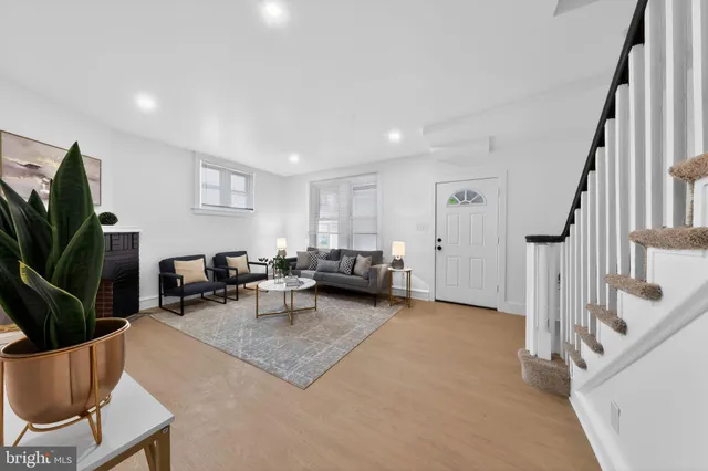 a living room with furniture a flat screen tv and a potted plant