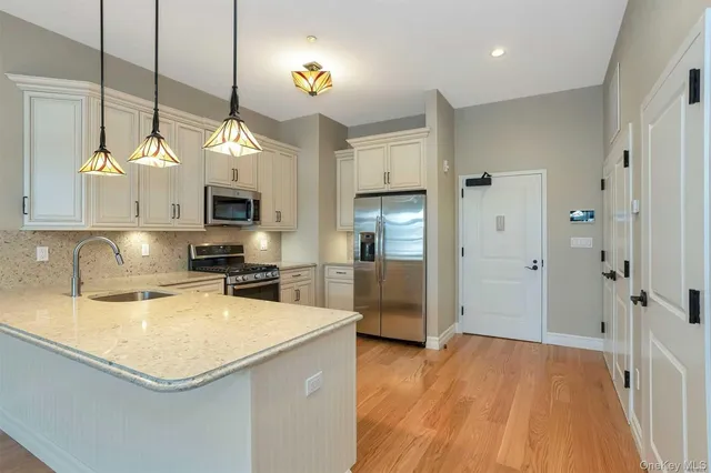 a kitchen with a sink a counter top space appliances and cabinets