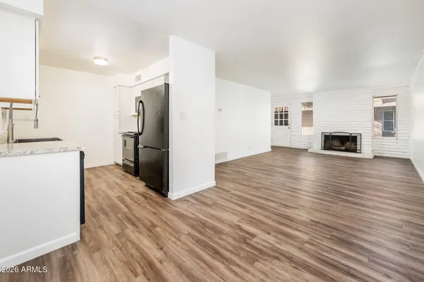 a view of empty room with wooden floor and fireplace