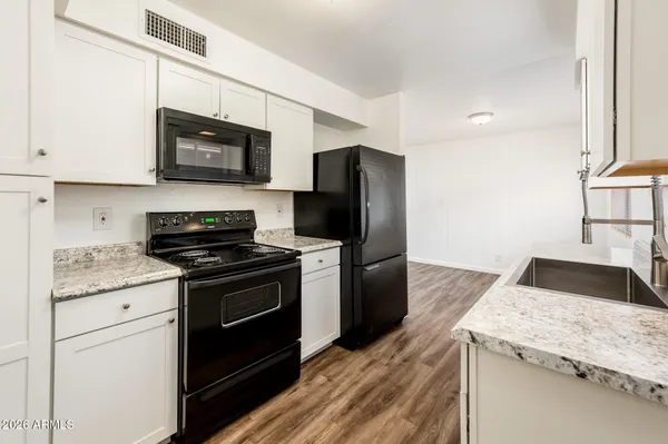 a kitchen with granite countertop a stove and a sink