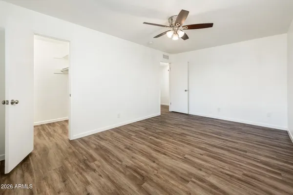 a view of a room with wooden floor and a ceiling fan