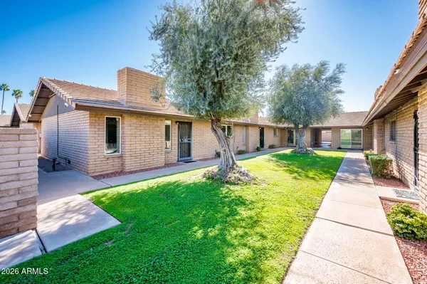 a view of a house with a yard and pathway