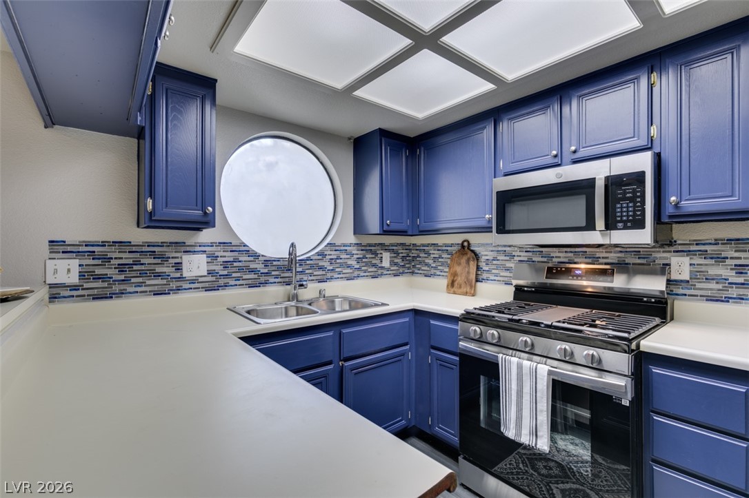 810 North Sloan Lane, Unit 103 Las Vegas, NV 89110 - Photo 9 of 16 Kitchen featuring stainless steel appliances, a sink, and blue cabinetry