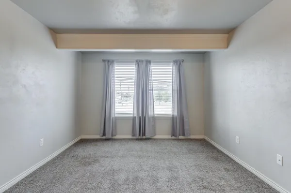 an empty room with a fireplace and window