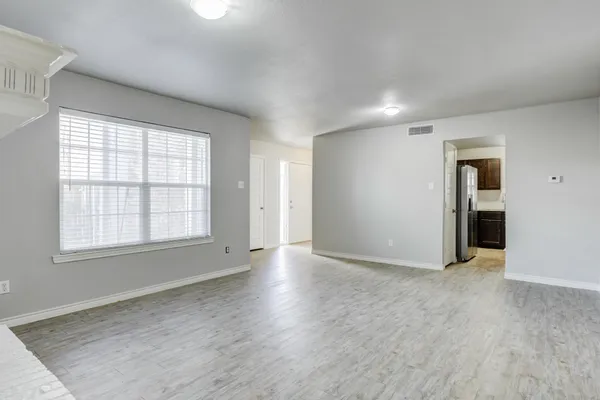 a kitchen with white cabinets and a wooden floor