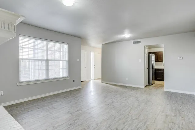 a kitchen with white cabinets and a wooden floor