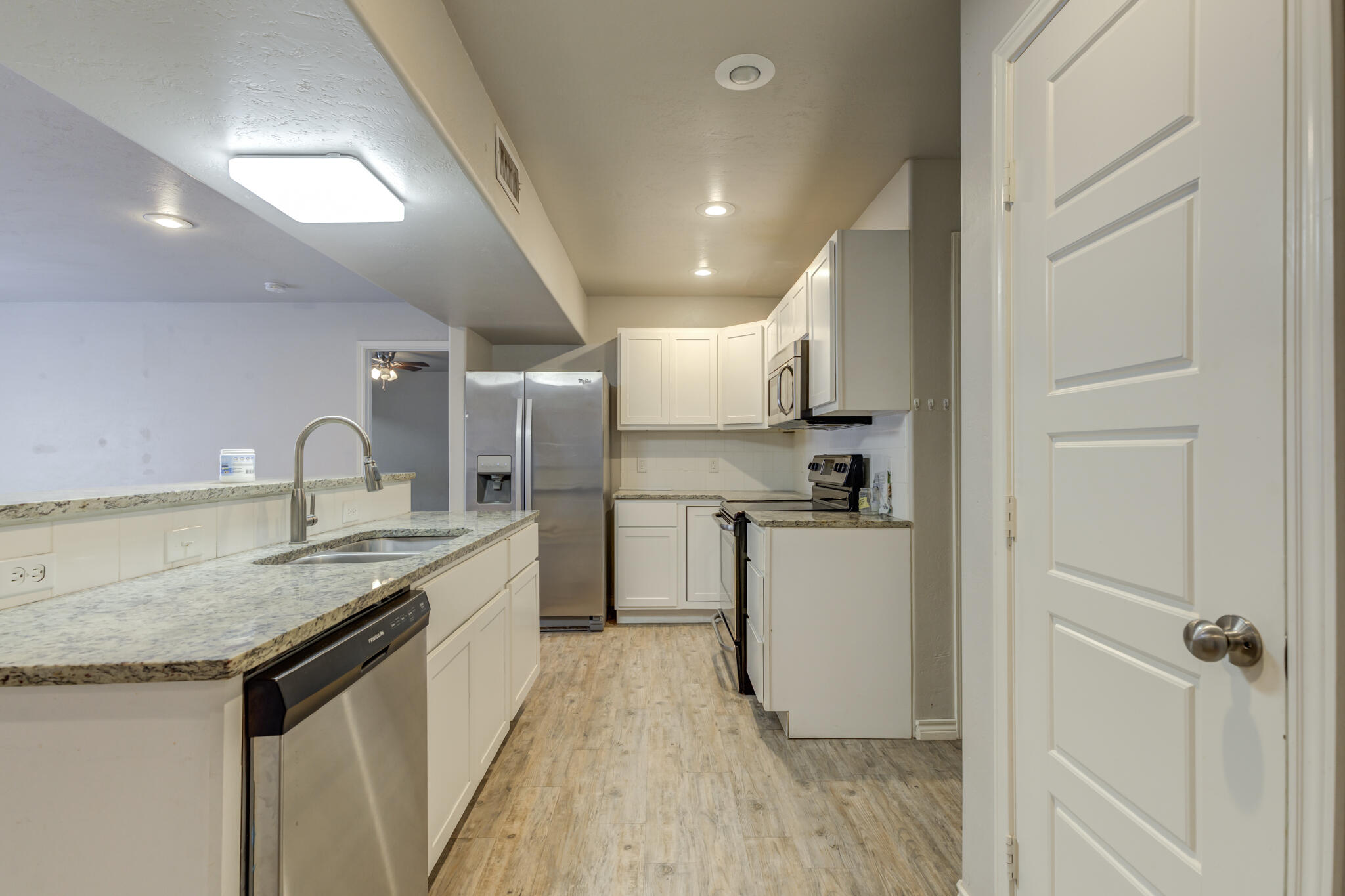 4320 52nd Street Lubbock, TX 79413 - Photo 4 of 59 a kitchen with a sink stainless steel appliances and white cabinets