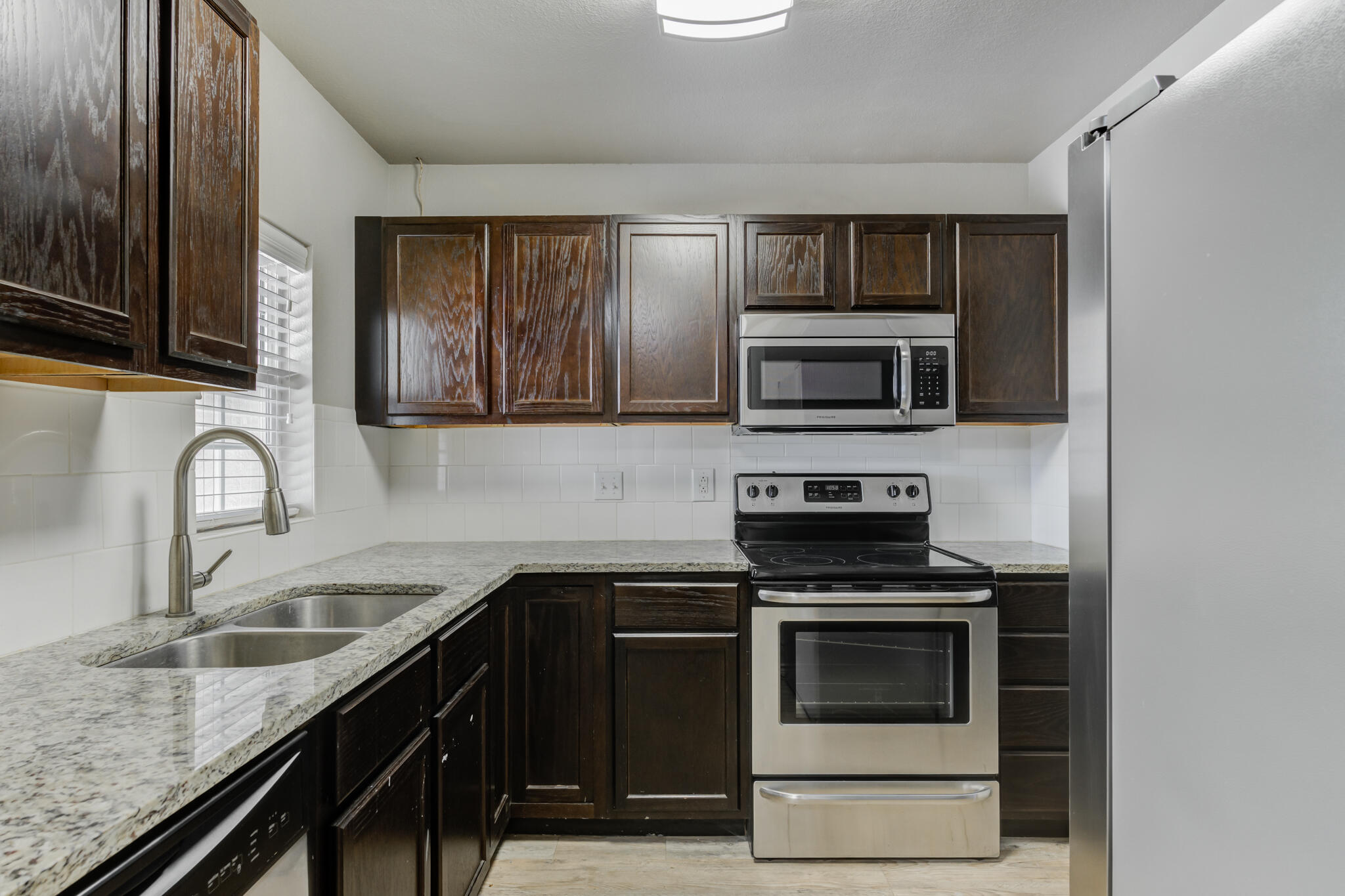 4320 52nd Street Lubbock, TX 79413 - Photo 44 of 59 a kitchen with granite countertop a stove microwave and sink