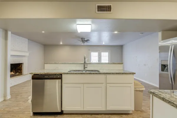 a kitchen with stainless steel appliances granite countertop a sink and a stove top oven